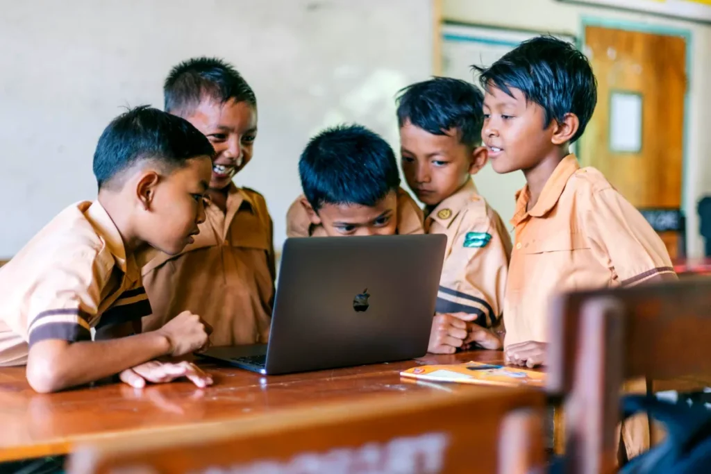 Group of school students using a laptop in classroom for digital learning